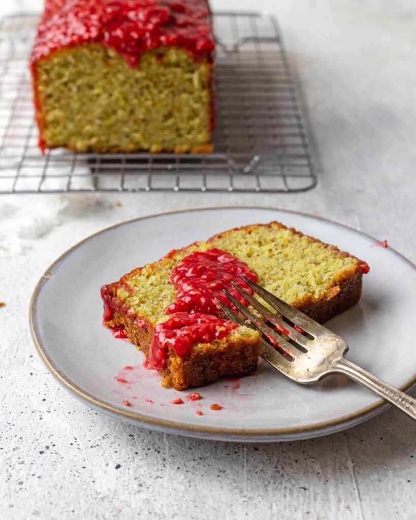 slice of pistachio pound cake covered in raspberry sauce